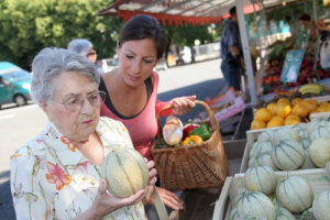 caregiver assisting an old woman in a grocery