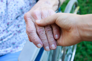 passionate caregiver holding the old woman's hands